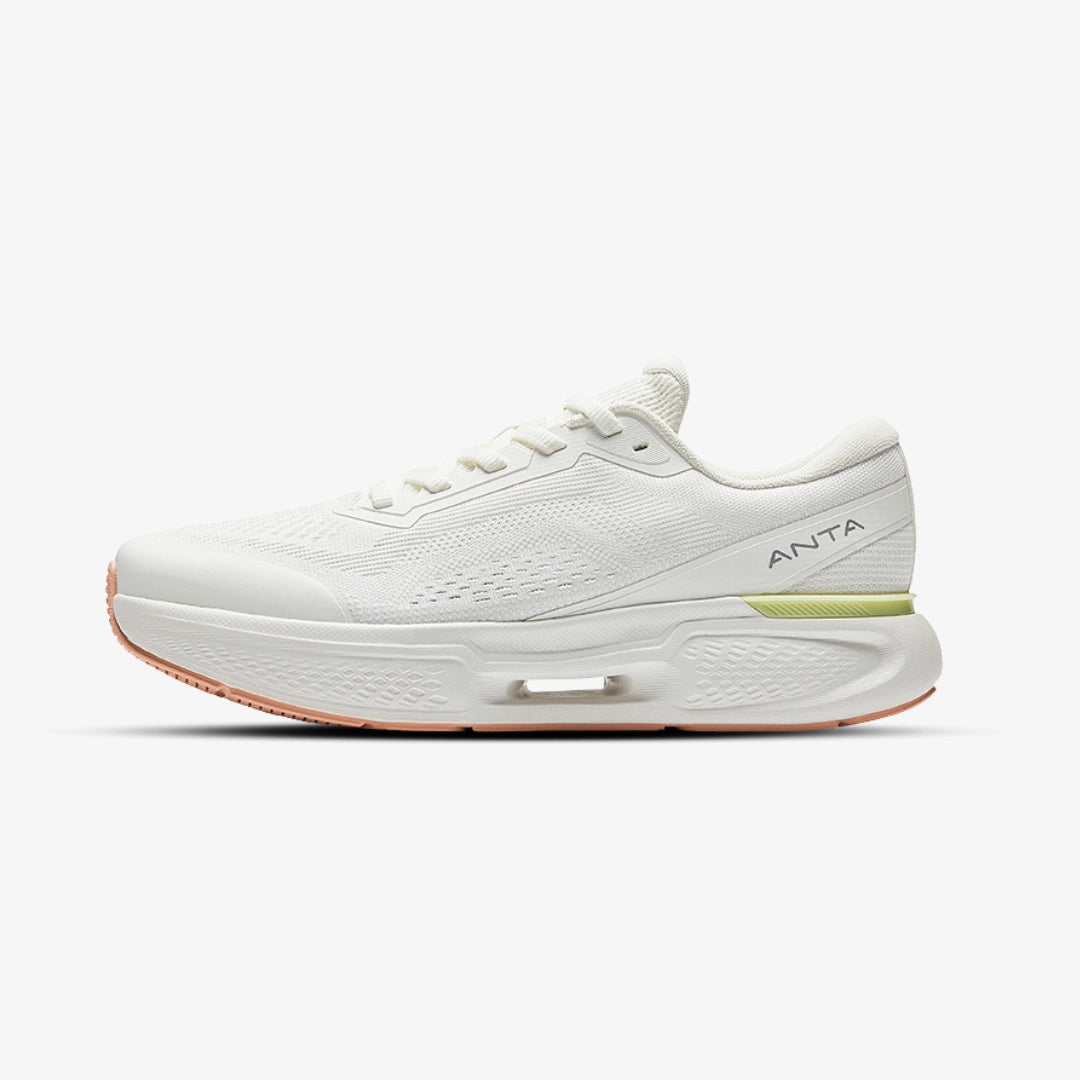 Chaussures de running Anta blanches pour homme, design moderne avec semelle épaisse légère et détails verts et orange, idéales pour la performance et le confort quotidien.