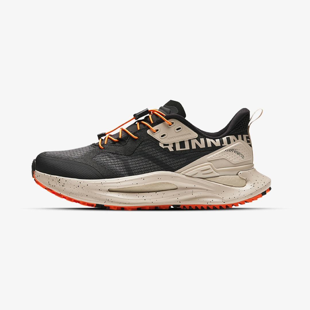 Chaussure de trail running Anta noire et beige avec semelle orange.


