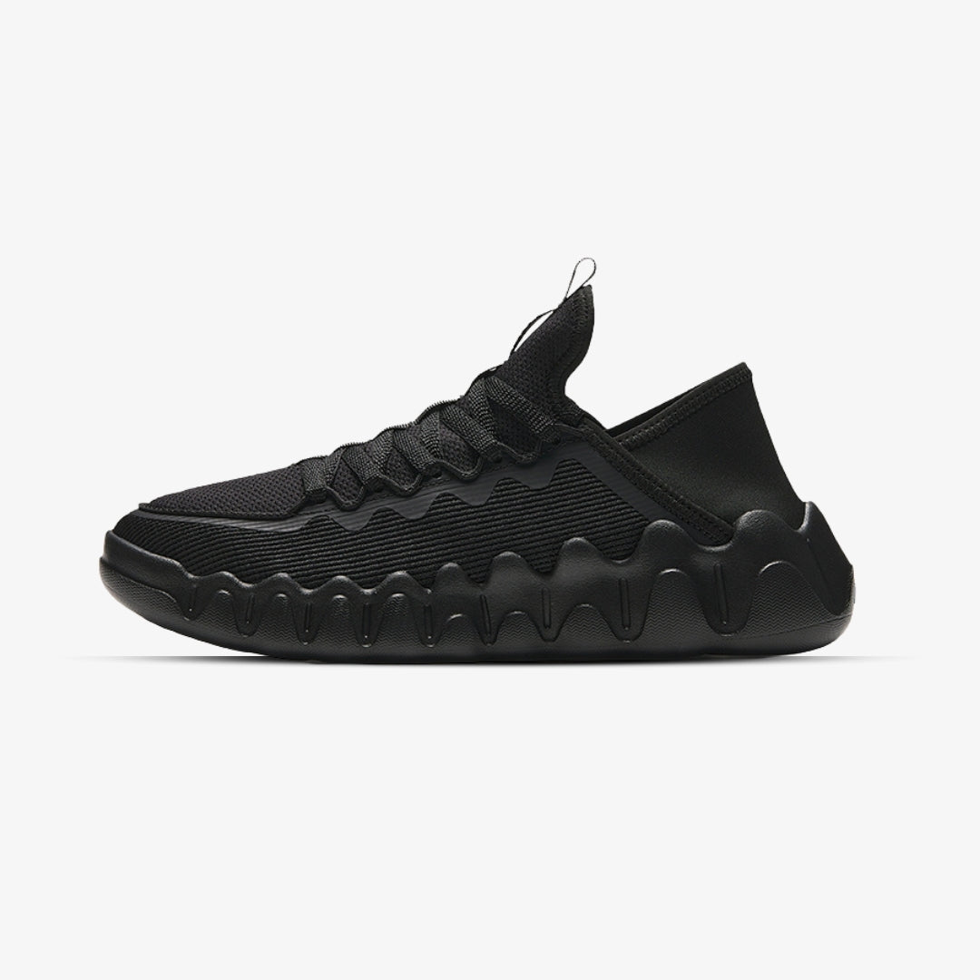 Baskets noires lifestyle avec tige respirante, semelle ondulée oversize et confort slip-on – look moderne et urbain